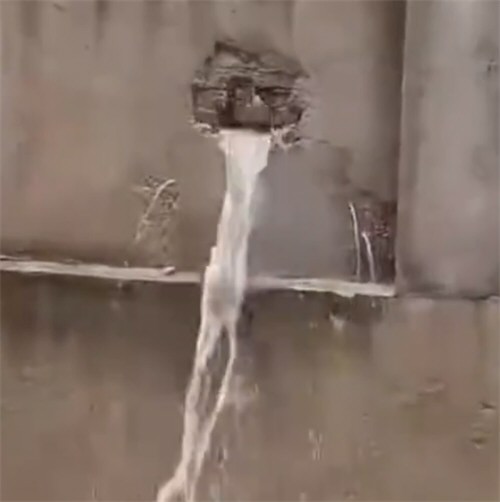 郑州暴雨一男子砸墙泄流隔壁小区